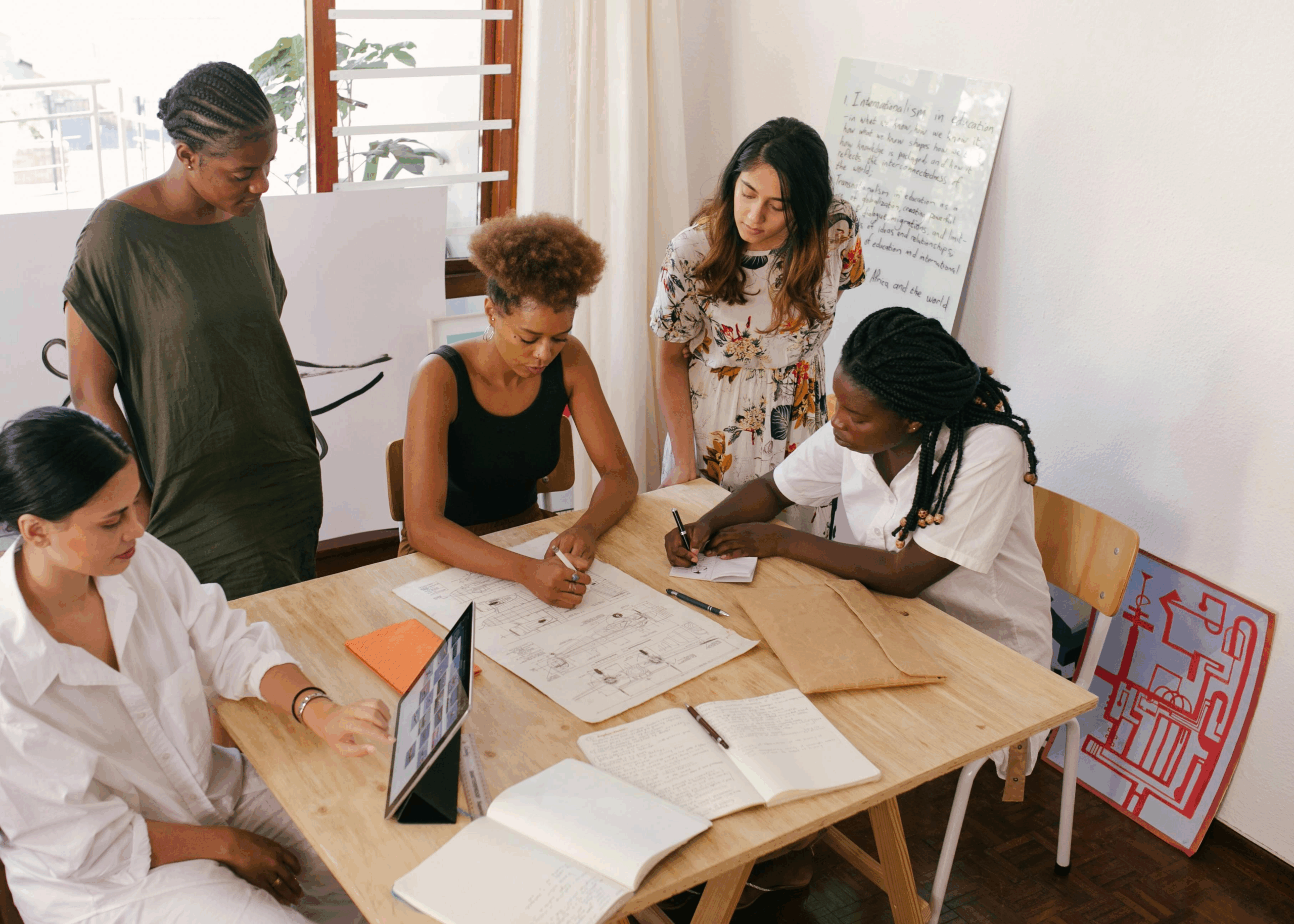 Un gruppo di persone collabora intorno a un tavolo.